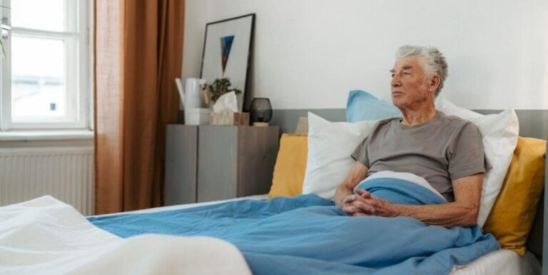 Senior Man Thinking while Sitting in a Bed in an Independent Living Facility