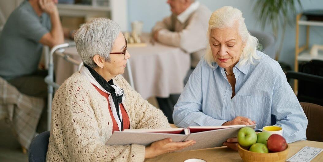 Elderly Women Reading Together and Talking at Independent Living Facility