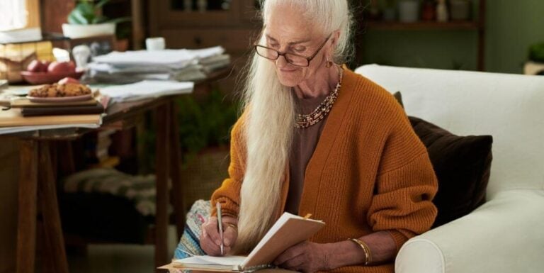 Elderly Woman Writing in Notebook at Independent Living Facility