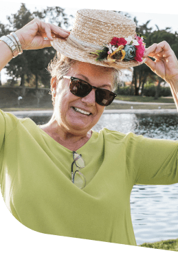 Cheerful Elderly Woman in Sunglasses Wearing a Straw Hat at an Independent Living Facility Cheerful Elderly Woman in Sunglasses Wearing a Straw Hat at an Independent Living Facility