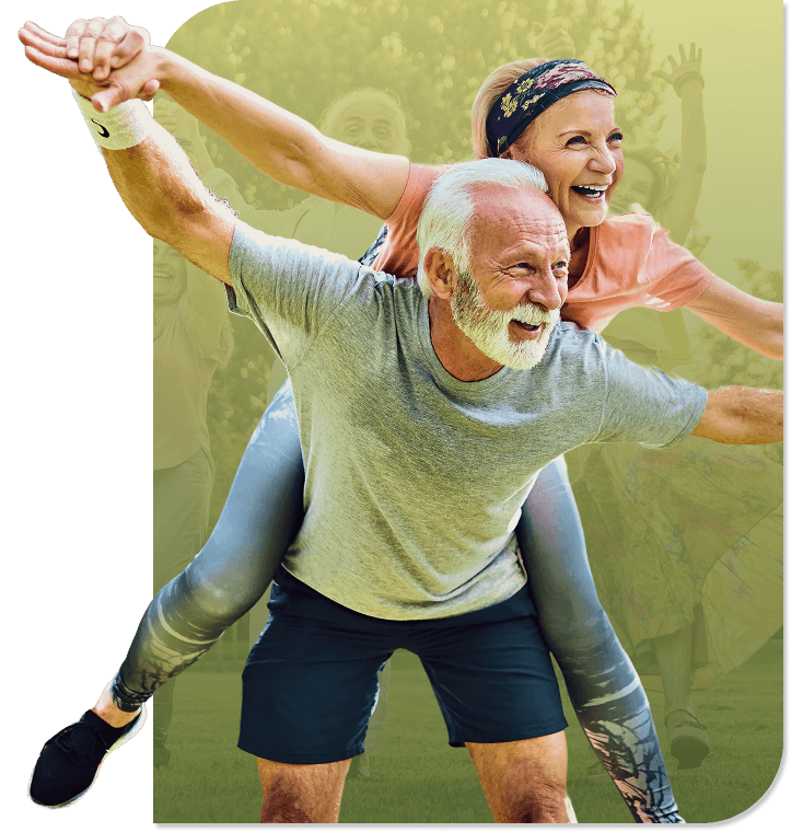 Smiling Elderly Couple Riding Bicycles Together Outdoors Near an Independent Living Facility Smiling Elderly Couple Riding Bicycles Together Outdoors Near an Independent Living Facility