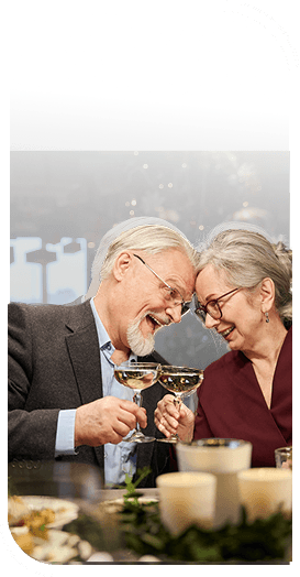 Affectionate Elderly Couple Toasting Champagne at a Holiday Dinner in Independent Living