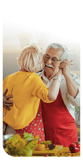 Elderly Couple Dancing Together While Cooking in the Kitchen at an Independent Living Facility