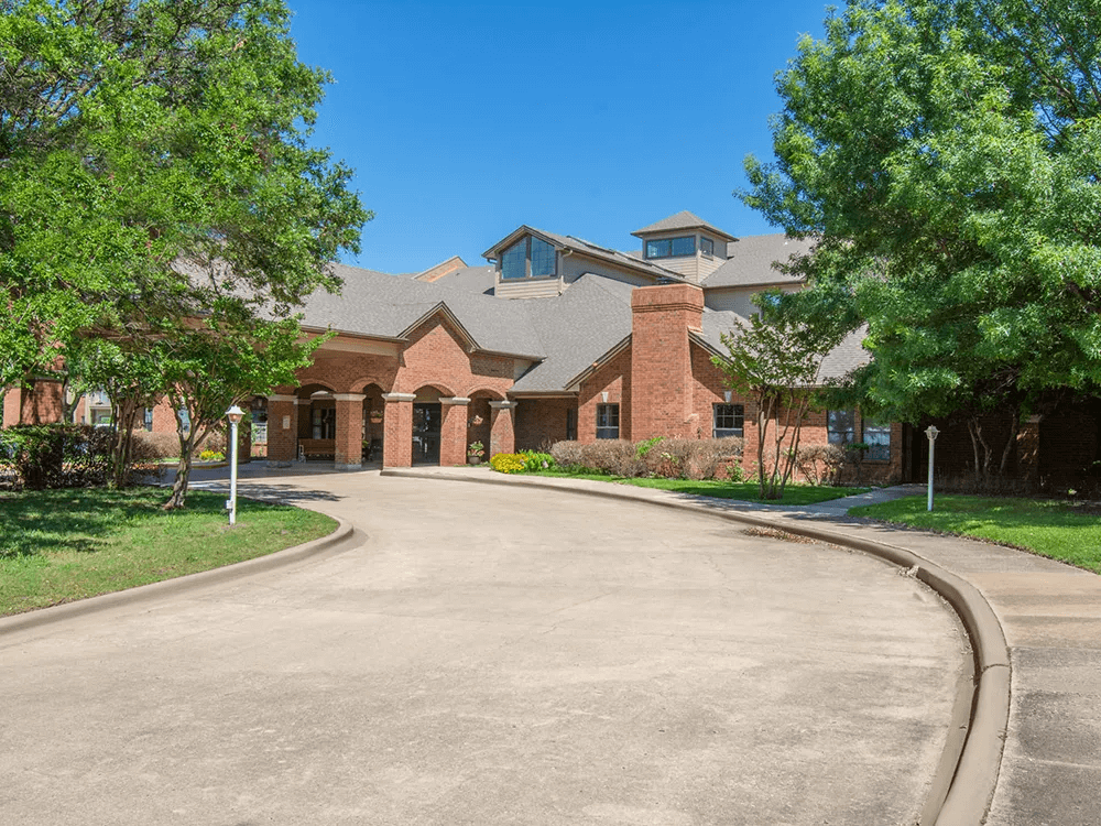 Brick Senior Residence with Circular Driveway and Mature Trees at Independent Living Community