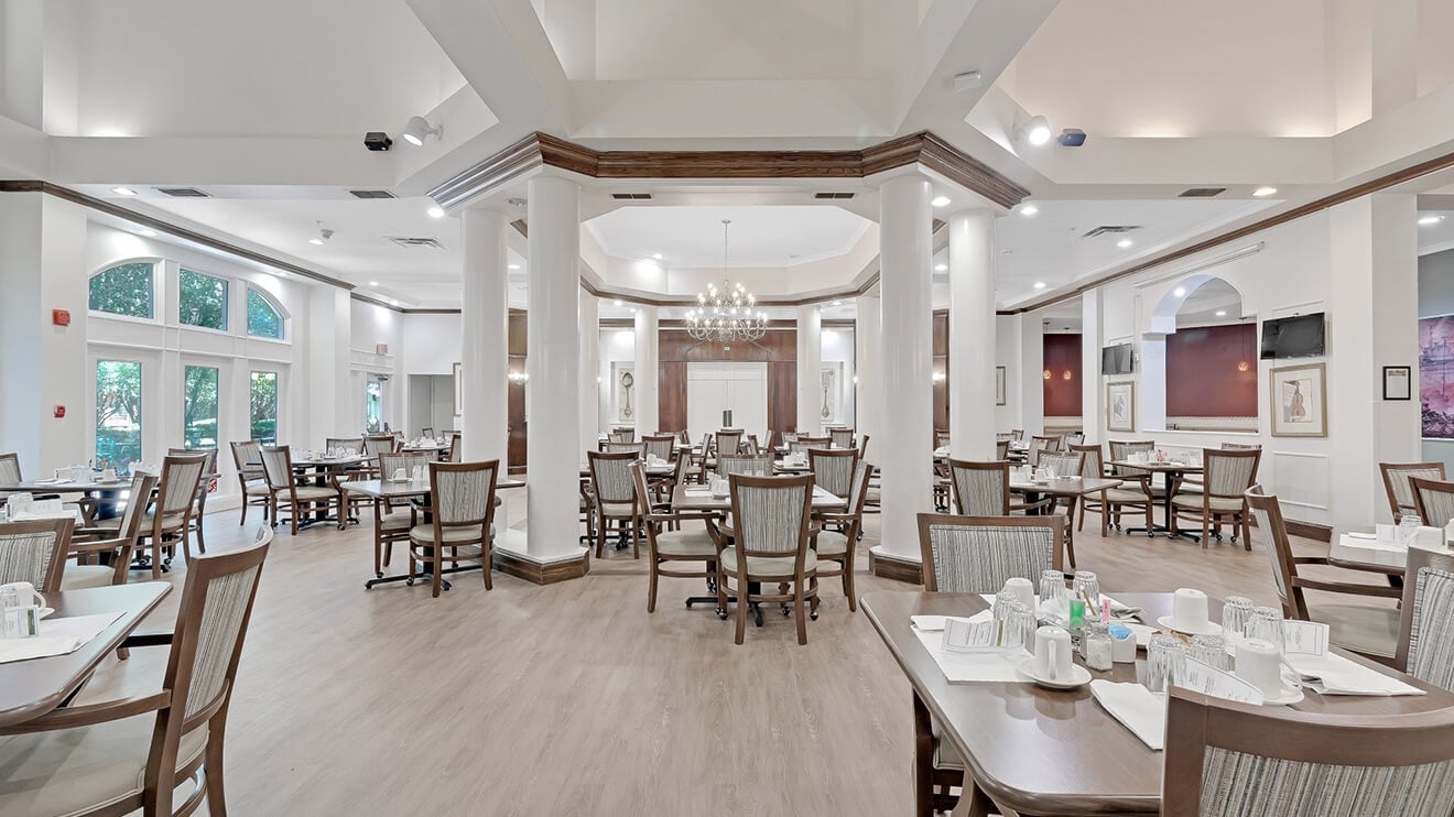 Elegant Dining Room with White Columns and Chandeliers for Independent Living