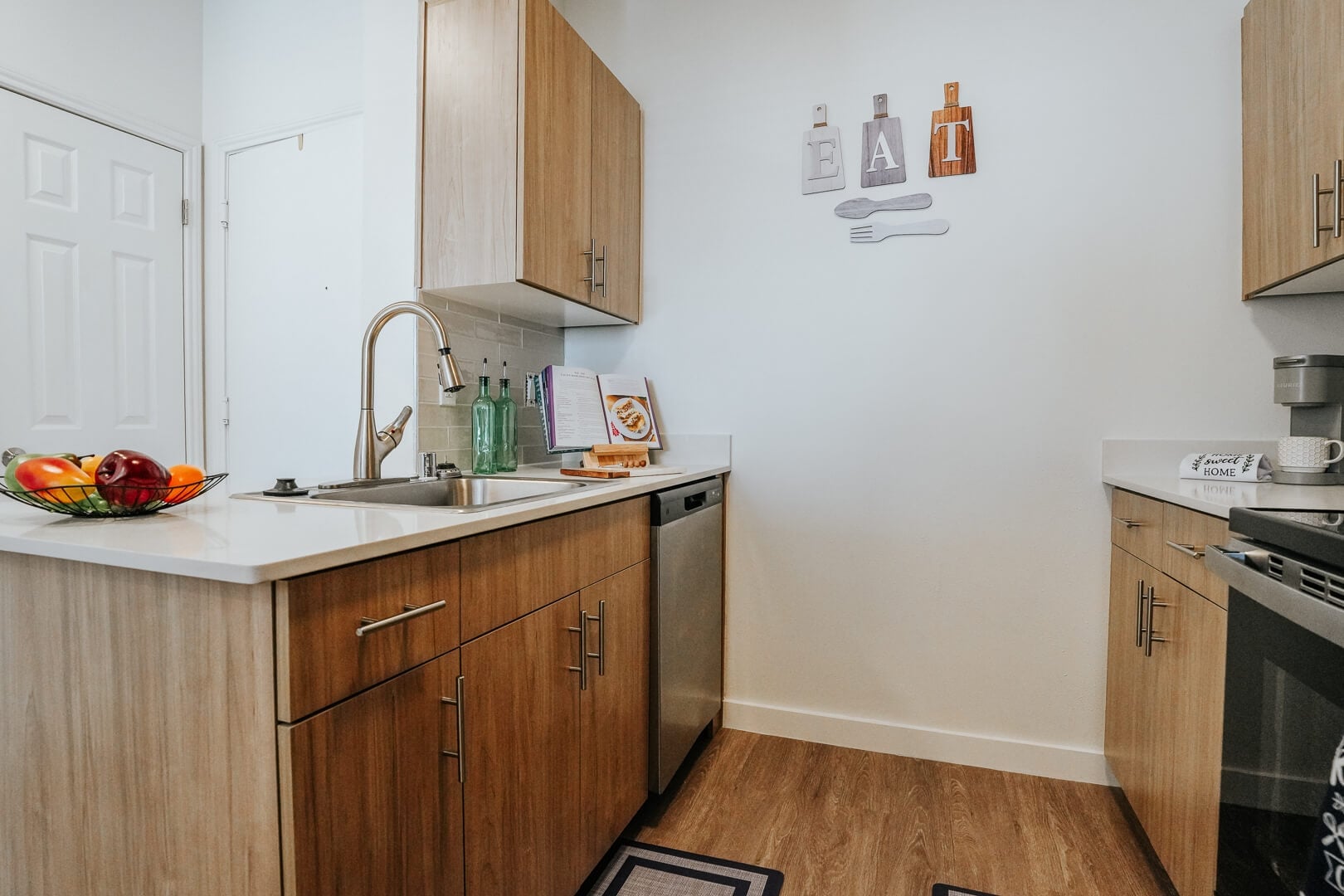 Compact Kitchen with Wood Cabinetry and Dishwasher inside Our Independent Living Facility