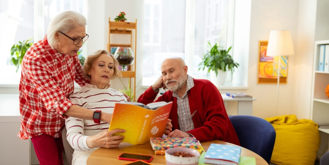Elderly Friends Reading a Book Together at Independent Living Facility